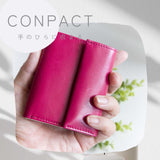 片手に収まるコンパクトなピンクの牛革財布