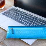 パイソン蛇革で仕立てた超薄型長財布。ブルーとネイビーのパイソン財布がカフェにある様子