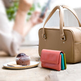 手のひらサイズのピンクのミニ財布がカフェにあるところ