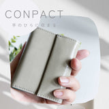 片手に収まるコンパクトなグレー色の牛革財布