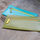 緑と青のバイカラーの厚さわずか2mmの長財布が二つ並んでカフェにある様子