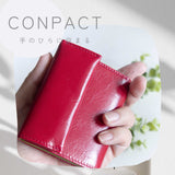 極小二つ折りの赤色コンパクト財布を手で持った写真