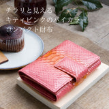 ピンクのパイソン蛇革財布がカフェにある様子
