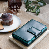 深い緑色の二つ折り財布がカフェにある様子