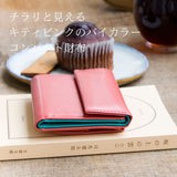 ピンクのおしゃれなコンパクト財布がカフェにある様子