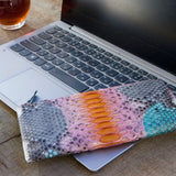 パイソン蛇革で仕立てたの超薄型長財布。ピンクなどのマルチカラーのパイソン財布がカフェにある様子。