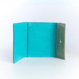 片手に収まるコンパクトなグレー色の牛革財布のカード入れ