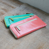 青とピンク色のL字ファスナー財布がカフェに並んでいる様子