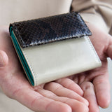 グレーのパイソン蛇革財布を手に持った様子|コンパクトで手のひらサイズ