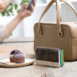 シックなブラウン系の蛇革のコンパクト財布がカフェにある素敵な様子