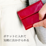 小さな赤いお財布をポケットに入れる様子