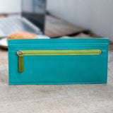 青と緑のバイカラーの厚さわずか2mmの長財布がカフェにある様子