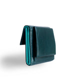 片手に収まるコンパクトなピンクの牛革財布の小銭入れ部分