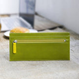 緑と黄色のバイカラーの厚さわずか2mmの長財布がカフェにある様子