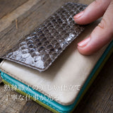 シックなブラウン系の蛇革のコンパクト財布をそっと手でなぞっている。柔らかで良質な革がうかがえる