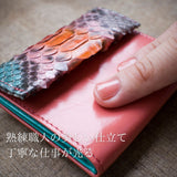 パイソン蛇革とイタリアの柔らかな牛革を指でなぞって柔らかさが分かる様子。綺麗な仕立てが分かる