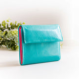 片手に収まるコンパクトな青(ターコイズブルー)の牛革財布の前からの写真