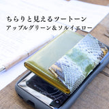 緑の蛇革ミニ財布財布がスマホの上に置かれている様子