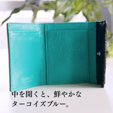 グレーとターコイズブルーのバイカラーの極小二つ折り財布を開いたところ