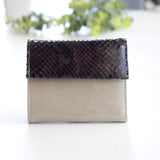 グレーのパイソン蛇革財布を手に持った様子|コンパクトで手のひらサイズ