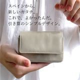 ライトグレーのコンパクト財布を手で持っている様子