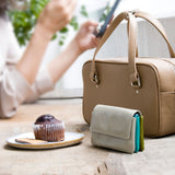 軽くて小さいライトグレーのコンパクト財布がカフェに素敵に置かれてある