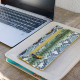 パイソン蛇革の超薄型長財布。緑色のパイソン財布がカフェにある様子。