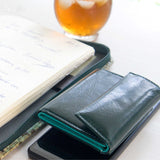 片手に収まるコンパクトなピンクの牛革財布