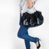 黒とパイソン柄の本革、レザーのトートバッグを腕に持つ女性