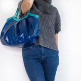 大き目のネイビーのバッグを肩から下げている様子