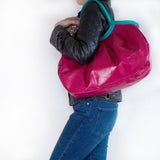 ピンク色のバイカラーのバッグを肩にかけている