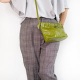 グリーンのミニバッグを肩から下げている様子