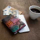 ピンク、オレンジ、ブルー、グレー4色のパイソン蛇革財布がカフェにある様子|超軽量で大容量な二つ折りレディース財布