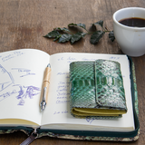 緑のパイソン蛇革財布がテーブルにある様子|超軽量で大容量な二つ折りレディース財布