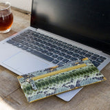 パイソン蛇革で仕立てたの超薄型長財布。緑色のパイソン財布がカフェにある様子。