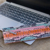 パイソン蛇革で仕立てたの超薄型長財布。ピンク色のパイソン財布がカフェにある様子。