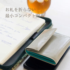 極小で薄い、ライトグレーのコンパクト財布のメインビジュアル。お札を折らない最小コンパクト財布と書いてある
