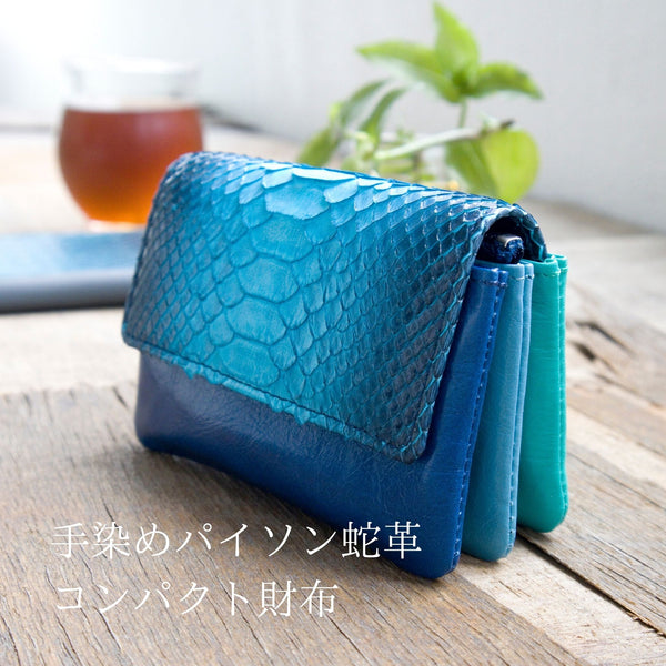 美しいブルーのグラデーションが特徴の蛇革の小さなカードサイズのコンパクト財布がカフェに置かれて素敵な様子