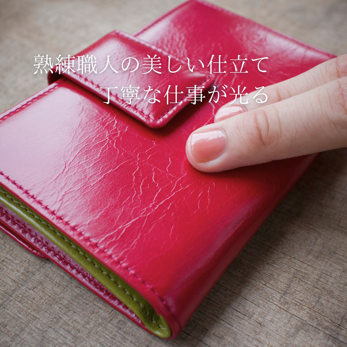 赤い二つ折り財布の柔らかい革を指でなぞっている