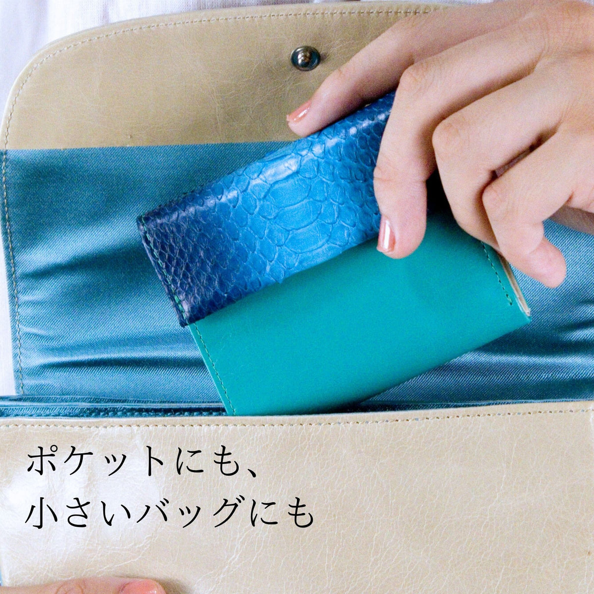 蛇革青いミニ財布を小さいなバッグに入れている様子