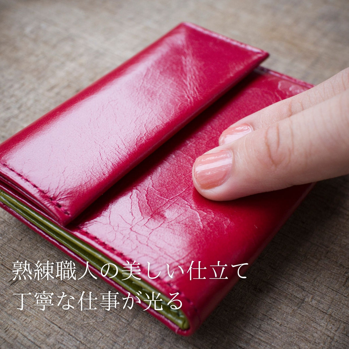 赤い、小さいお財布を指で押さえて柔らか輪を高めている