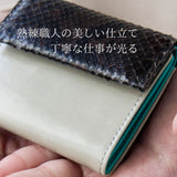 グレーとターコイズブルーのバイカラーの極小二つ折り財布の仕立てが見える様子