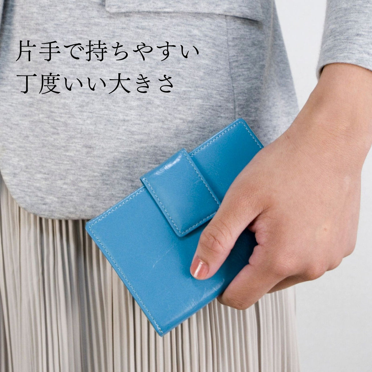 青い二つ折り財布を手で持っている問ころ