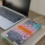 パイソン蛇革で仕立てた超薄型長財布。ピンクとオレンジのパイソン財布がカフェにある様子