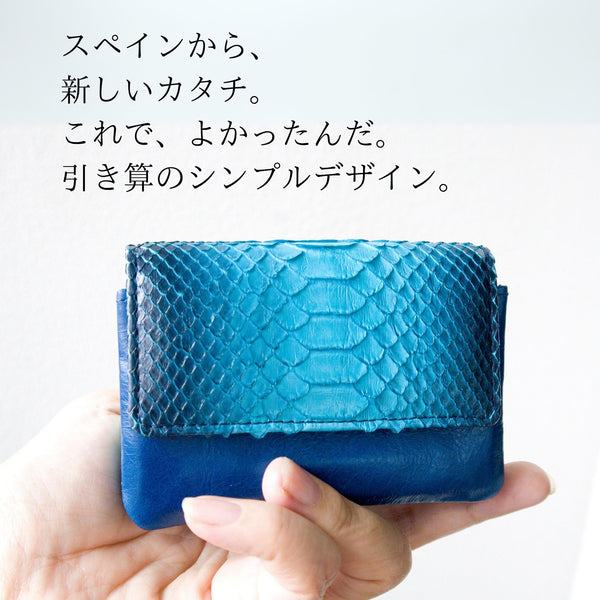 美しいブルーのグラデーションが特徴の蛇革の小さなカードサイズのコンパクト財布を手のひらに置き、大きさが分かりやすくなっている様子