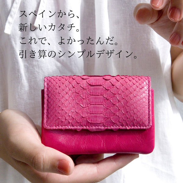 大人ピンクの、小さなカードサイズのコンパクト財布を両手で持っているところ