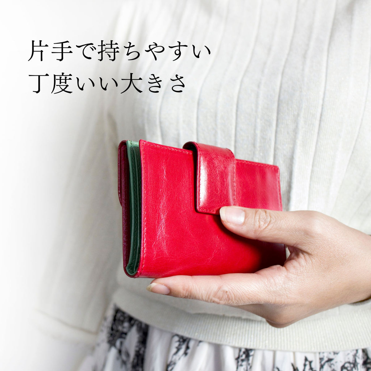赤い二つ折り財布を片手で持っている