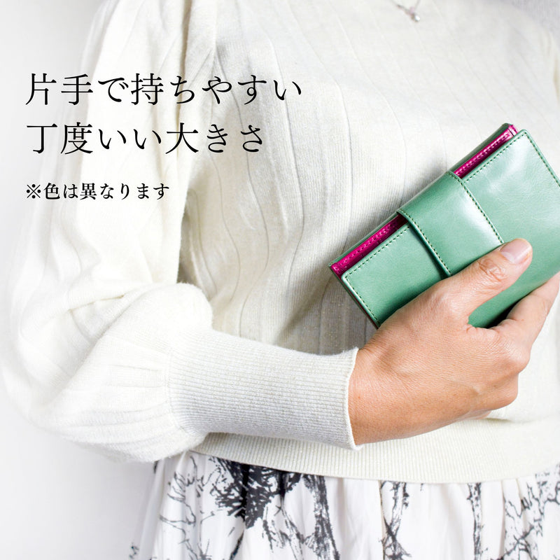 緑の二つ折り財布を手で持っている様子