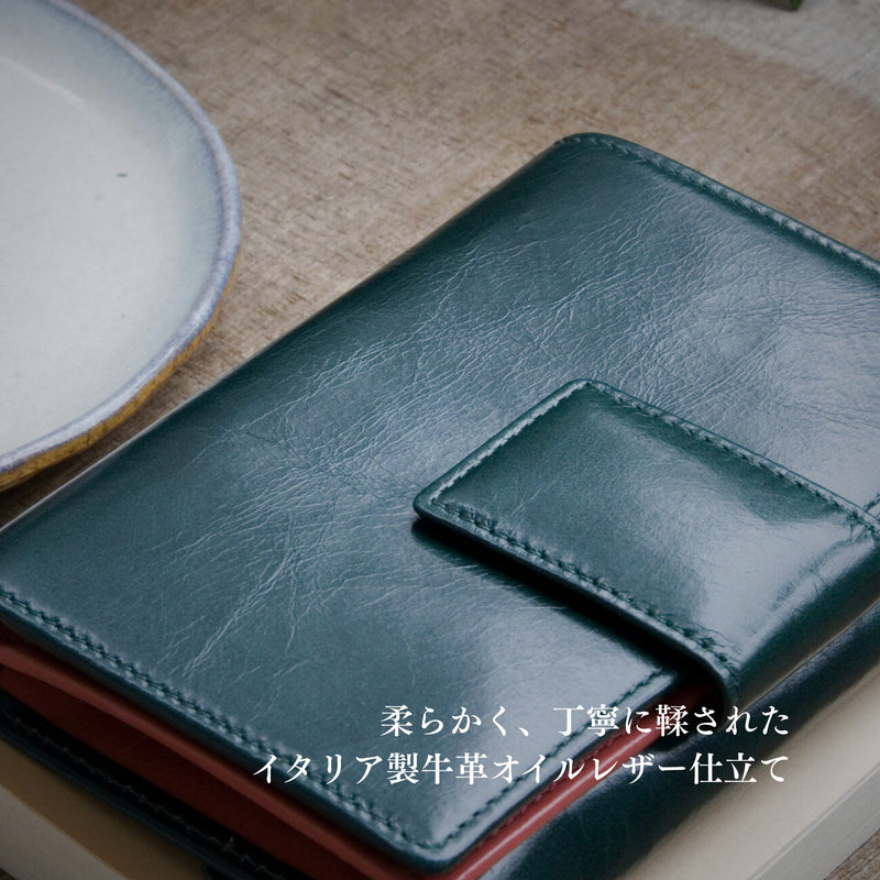 深い緑の二つ折り財布の仕立ての良さと革の夜話逆さが伝わる様子