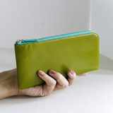 緑のL字ファスナー長財布を手に取っている様子